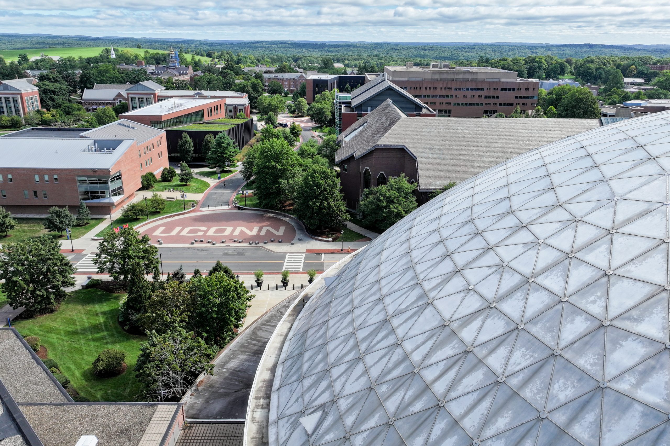 An aerial view of the UConn wordmark on Fairfield Way on a sunny day in Storrs.
